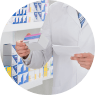 A pharmacist in his white lab coat reviews a prescription and a patient’s medication